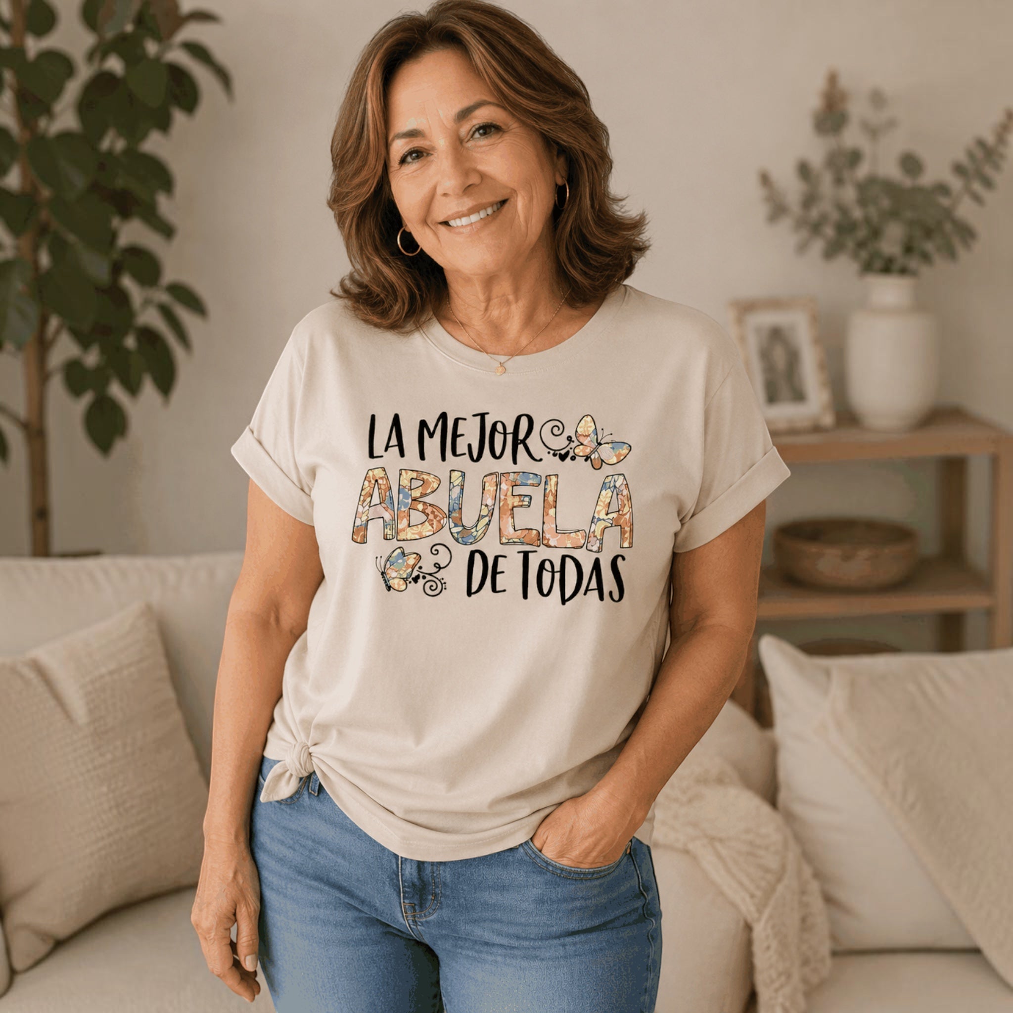 The Beauty Closet beige graphic t-shirt featuring La Mejor Abuela de Todas text and butterfly designs on a woman