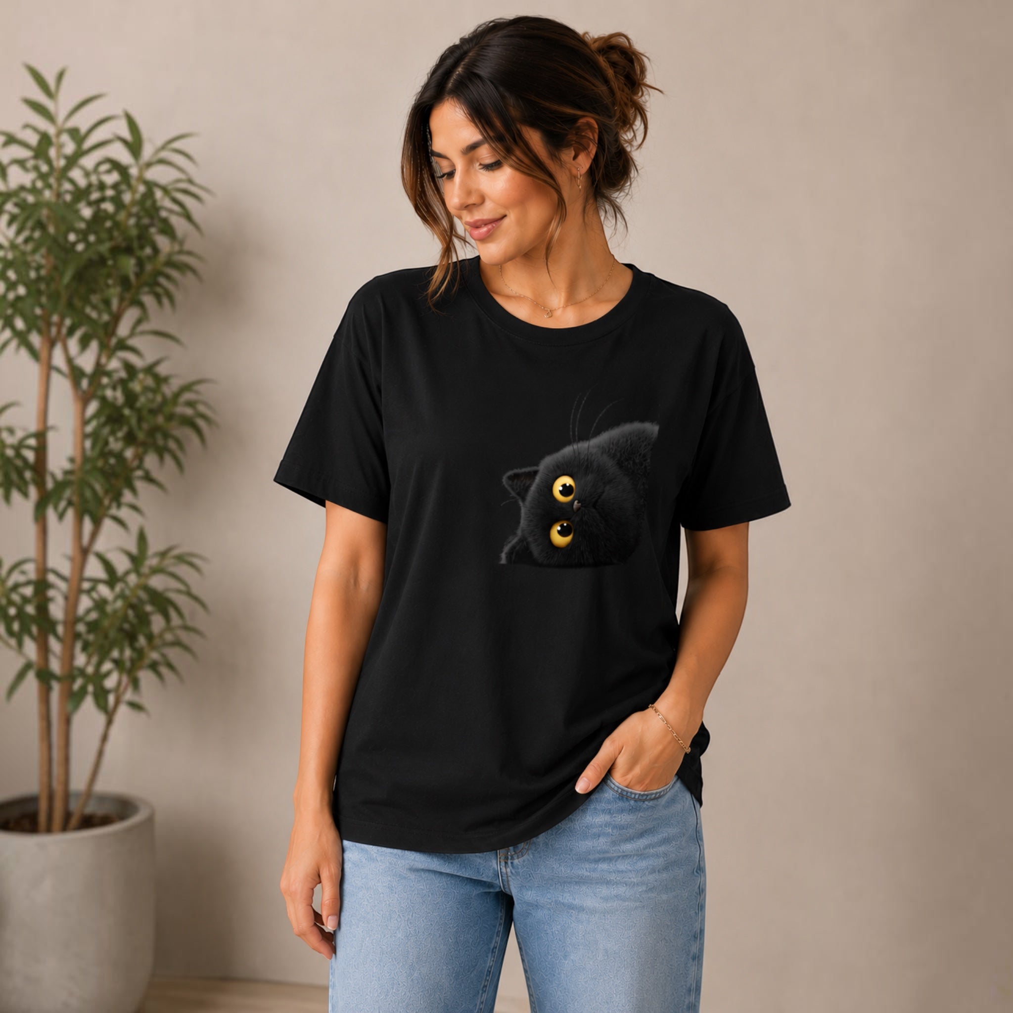 The Beauty Closet black cotton t-shirt with a playful black cat graphic peeking from the pocket. Relaxed fit, crew neck.
