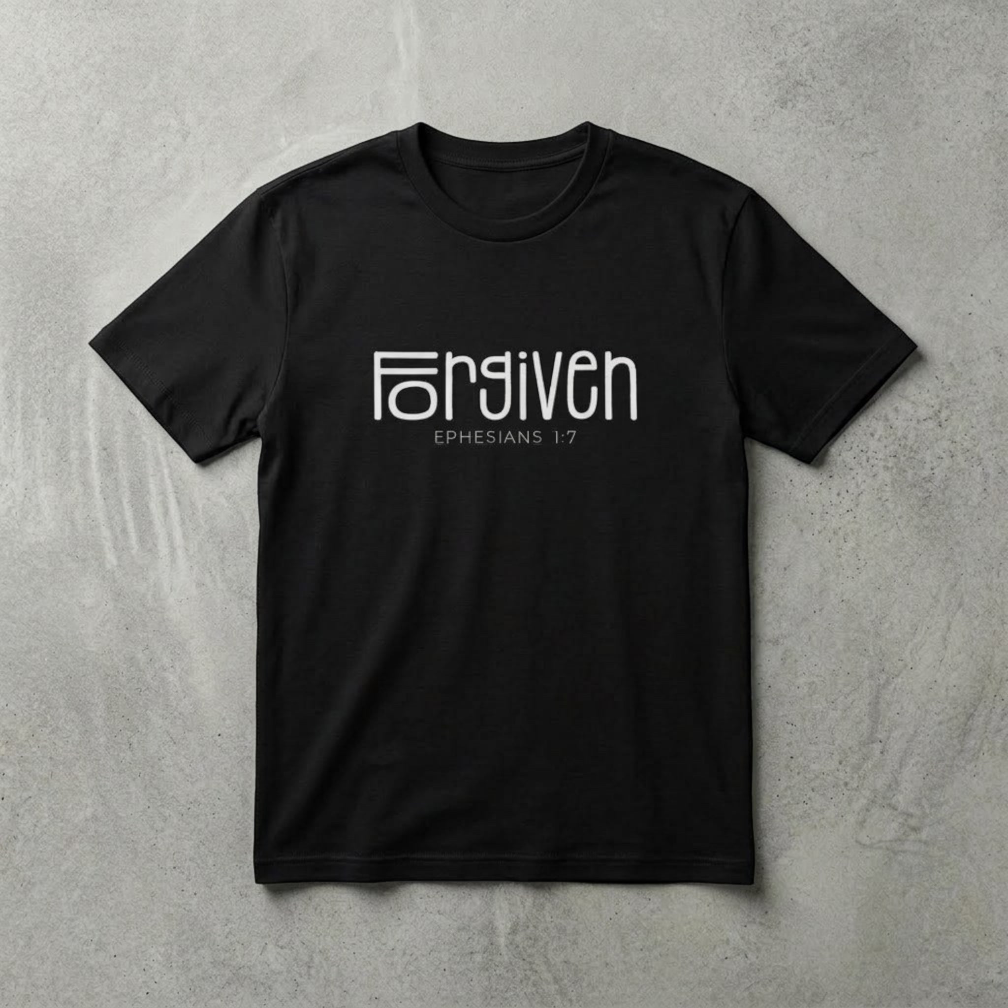 The Beauty Closet black cotton t-shirt featuring white Forgiven Ephesians 1:7 graphic text on a grey background.