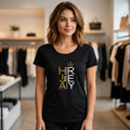 The Beauty Closet black cotton t-shirt with Hija del Rey graphic print worn by a woman in a clothing store