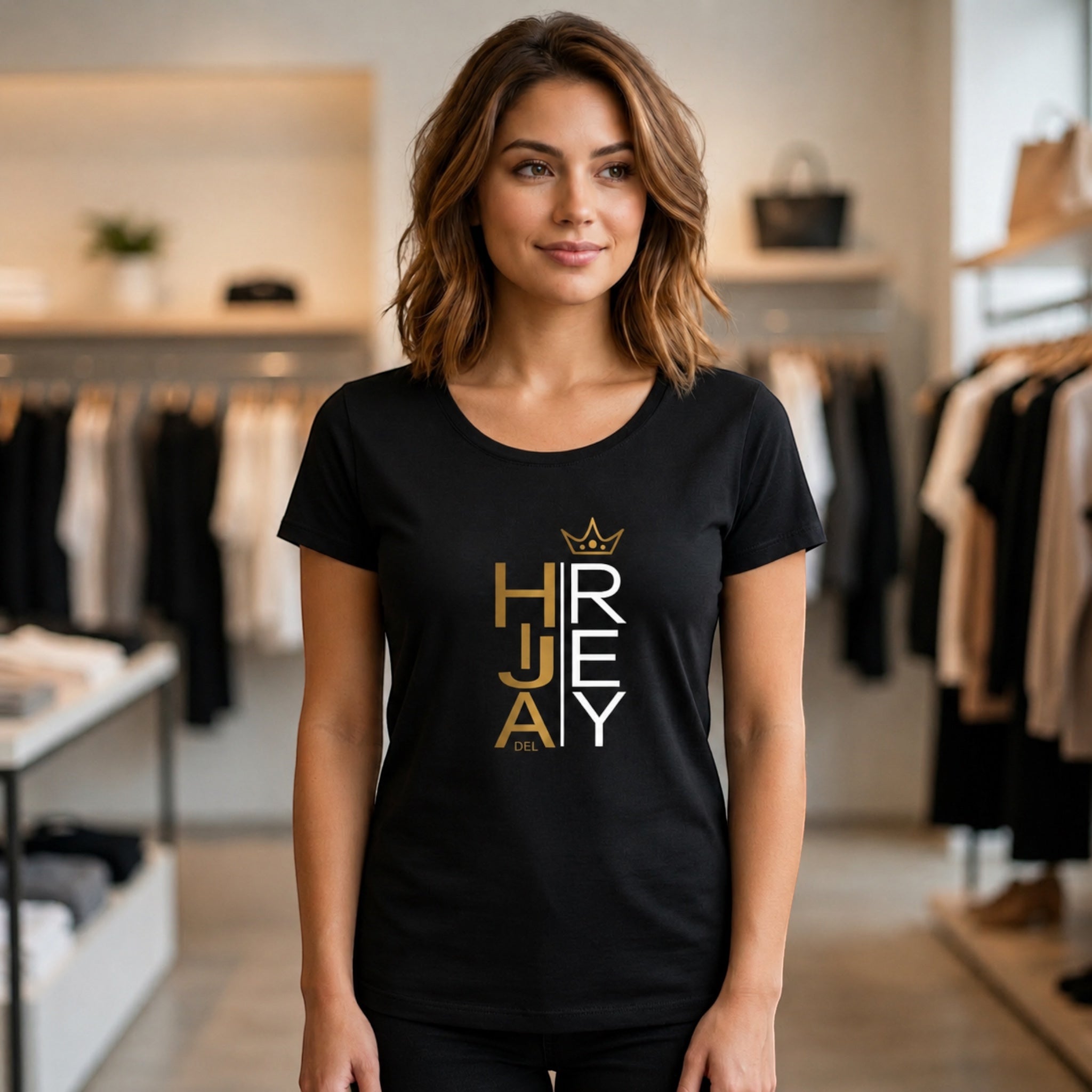 The Beauty Closet black cotton t-shirt with Hija del Rey graphic print worn by a woman in a clothing store