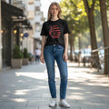 The Beauty Closet black cotton t-shirt with red heart graphic and Spanish Bible verse 1 John 4:19.