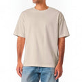 The Beauty Closet cream cotton crewneck t-shirt with a relaxed fit worn by a man with blue denim jeans.