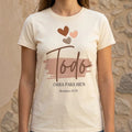 The Beauty Closet cream cotton crewneck t-shirt featuring a brown Todo graphic print with hearts and Bible verse.