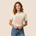 The Beauty Closet cream cotton t-shirt with God Is Good floral graphic print worn by a woman with blue jeans