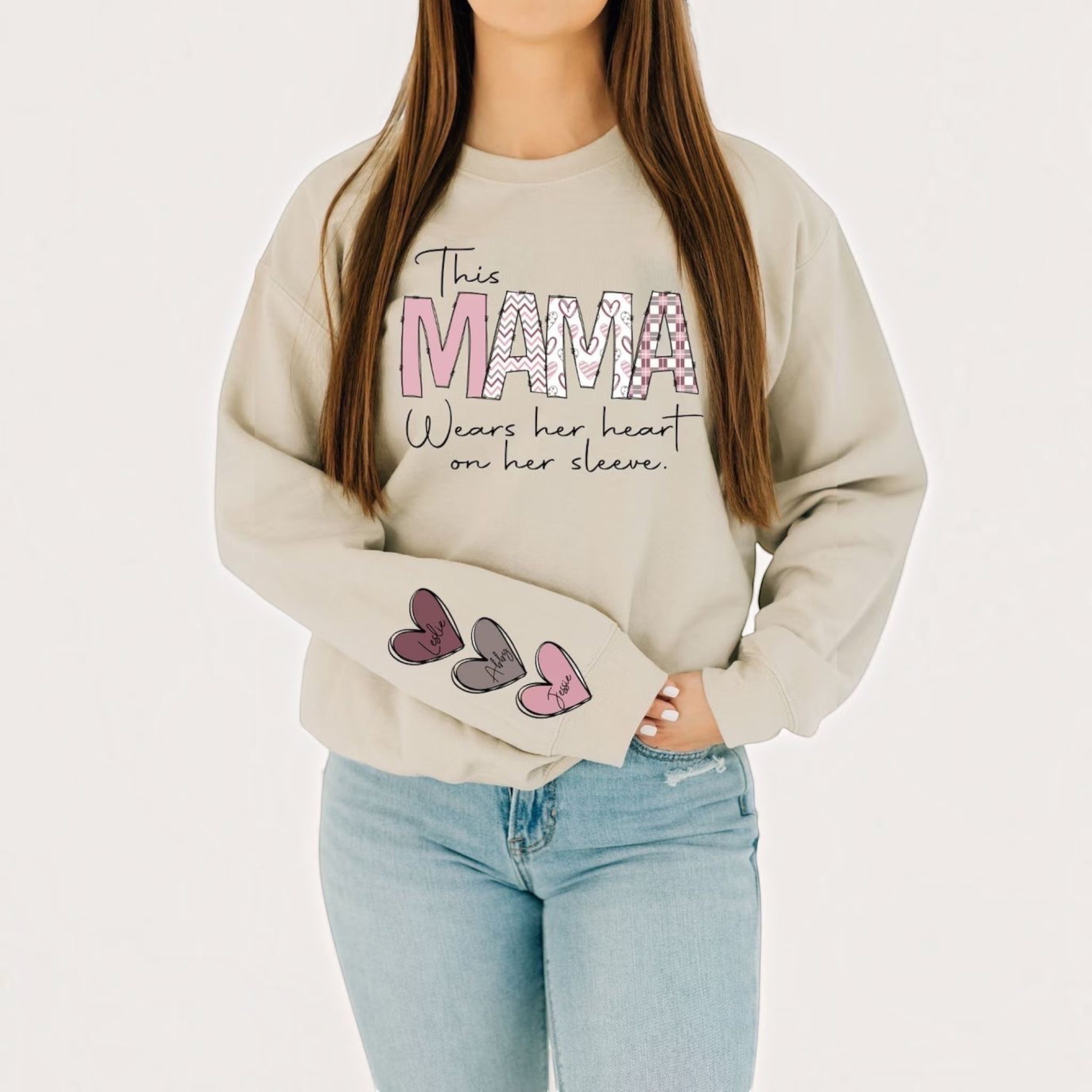 The Beauty Closet cream crewneck sweatshirt with MAMA graphic and heart sleeve detail worn by a woman