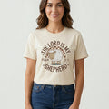 Woman wearing a cream The Beauty Closet t-shirt with a brown graphic of a sheep and The Lord Is My Shepherd text