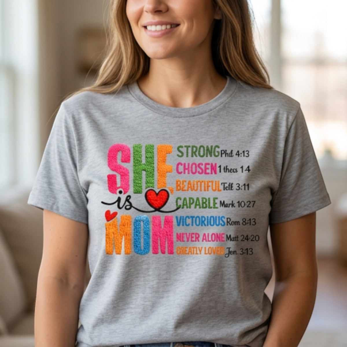 The Beauty Closet grey crewneck t-shirt featuring a colorful She Is Mom graphic print with inspirational text.