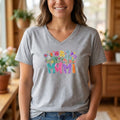 The Beauty Closet grey v-neck t-shirt with a colorful floral MAMI graphic print worn by a smiling woman