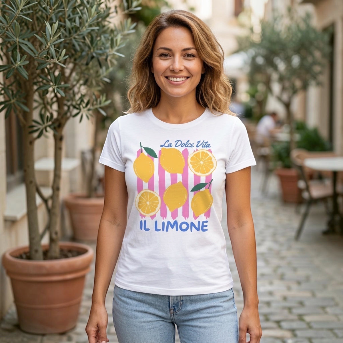 A woman wearing a The Beauty Closet white cotton crewneck t-shirt with a lemon and pink stripe graphic print.