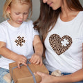 The Beauty Closet mommy and me white cotton t-shirts with matching leopard print puzzle piece heart designs.