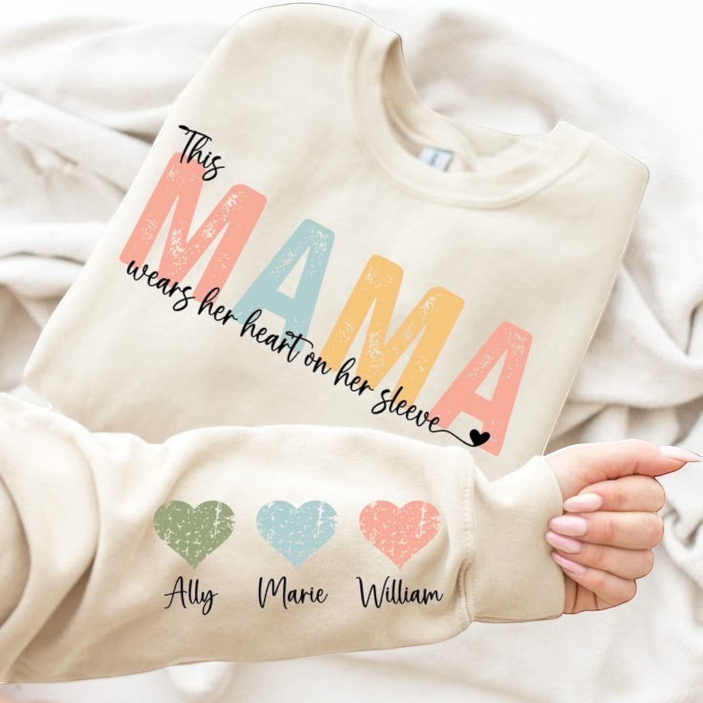 The Beauty Closet cream crewneck sweatshirt with Mama graphic and personalized heart sleeve detail for Disney moms.