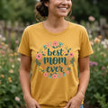 The Beauty Closet mustard yellow crewneck t-shirt featuring a Best Mom Ever floral graphic print on a woman