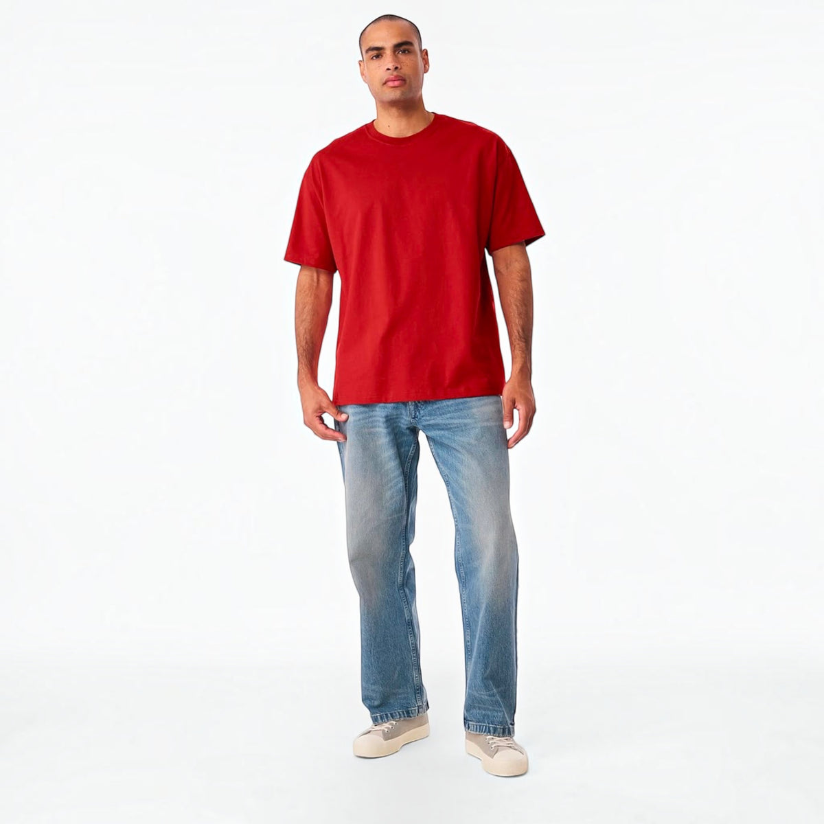 The Beauty Closet red crewneck cotton t-shirt worn by a man with blue jeans and sneakers against a white background