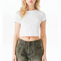 The Beauty Closet white cotton crewneck crop top worn by a woman with blonde hair paired with olive green jeans