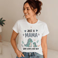 Woman wearing a white The Beauty Closet graphic t-shirt with a cute dinosaur illustration and Just a Mama text.