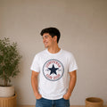 Man wearing a white The Beauty Closet t-shirt with a blue and red circular graphic print on the chest