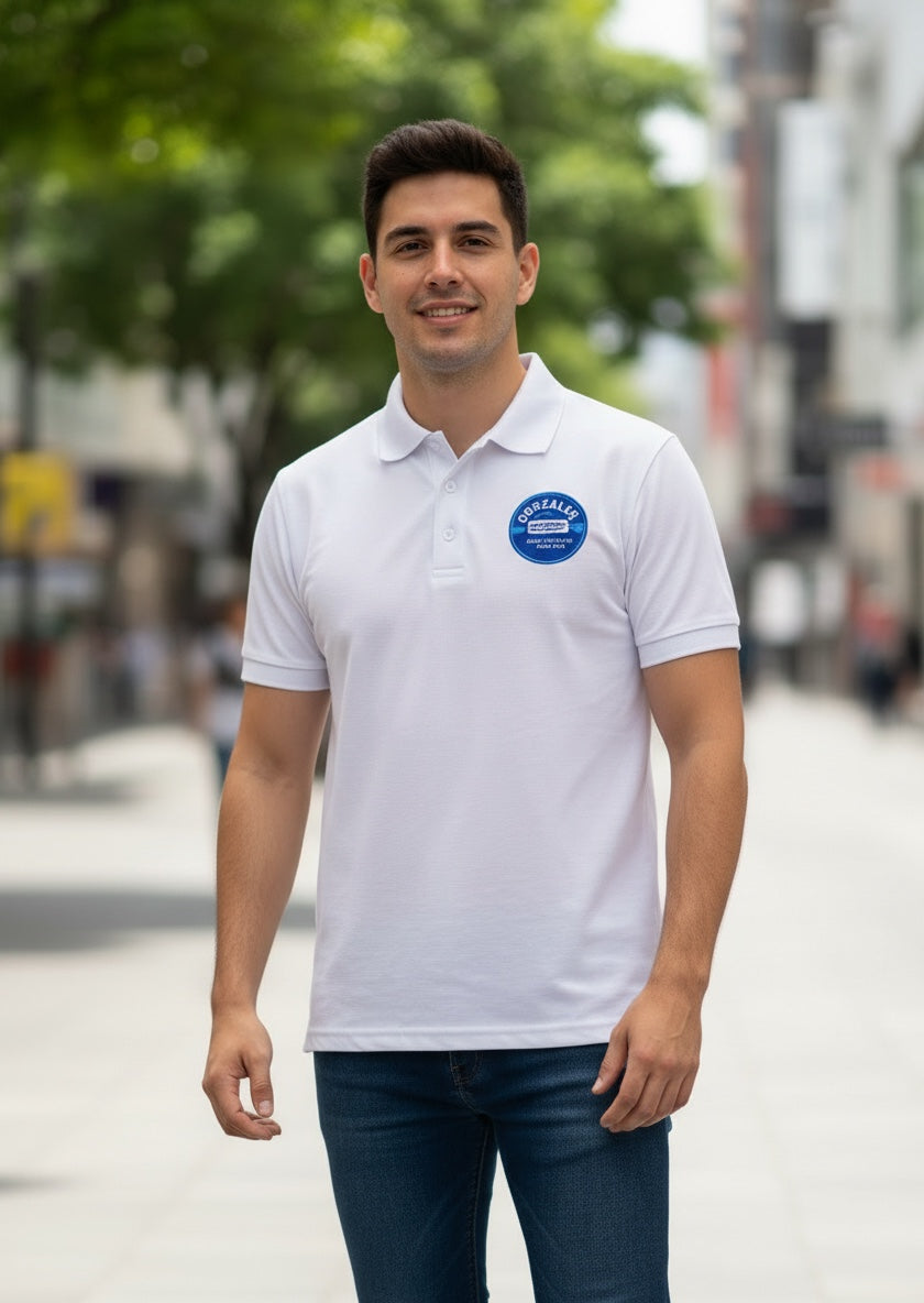 The Beauty Closet white polo shirt with a blue circular logo patch worn by a man in a city setting.