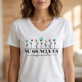 The Beauty Closet white v-neck t-shirt with floral graphic and Su Gracia Es Suficiente text on a woman