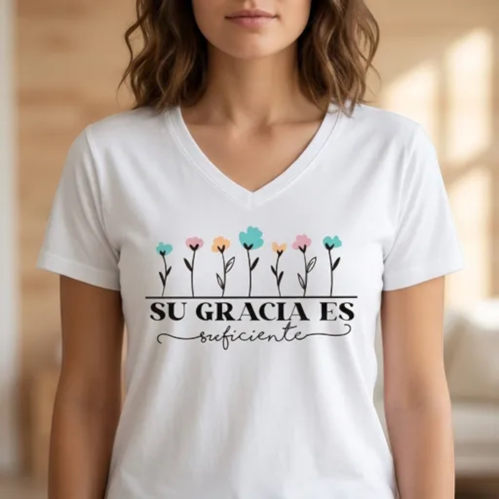 The Beauty Closet white v-neck t-shirt with floral graphic and Su Gracia Es Suficiente text on a woman
